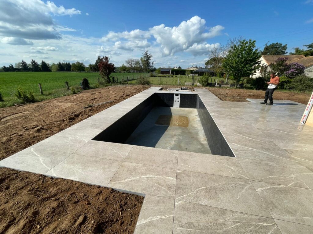 Chantier piscine entouree de carrelages.